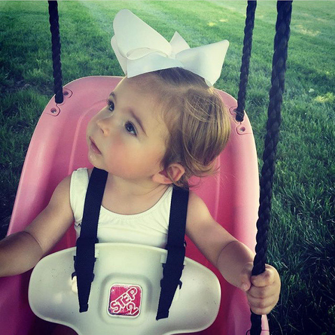 baby girl wearing an extra large 6 inch hair bow in white