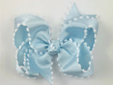 light blue and white hair bow with pom poms
