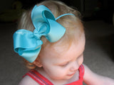 baby girl wearing an aqua blue 4 inch bow headband