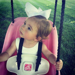 baby in a swing with an extra large jumbo white hair bow